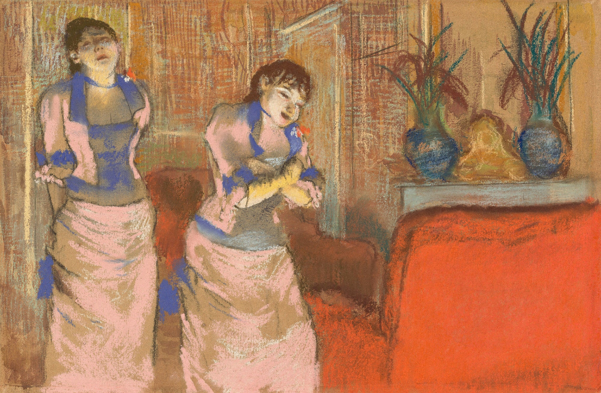 Two women in a room with a red couch and decorative vases.